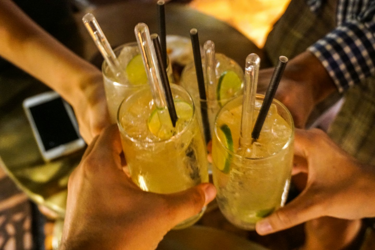 Friends clink glasses filled with cocktails during a toast.